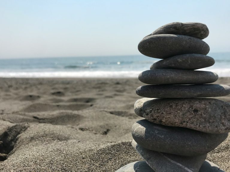 About 3 Stack of stones on beach during daytime